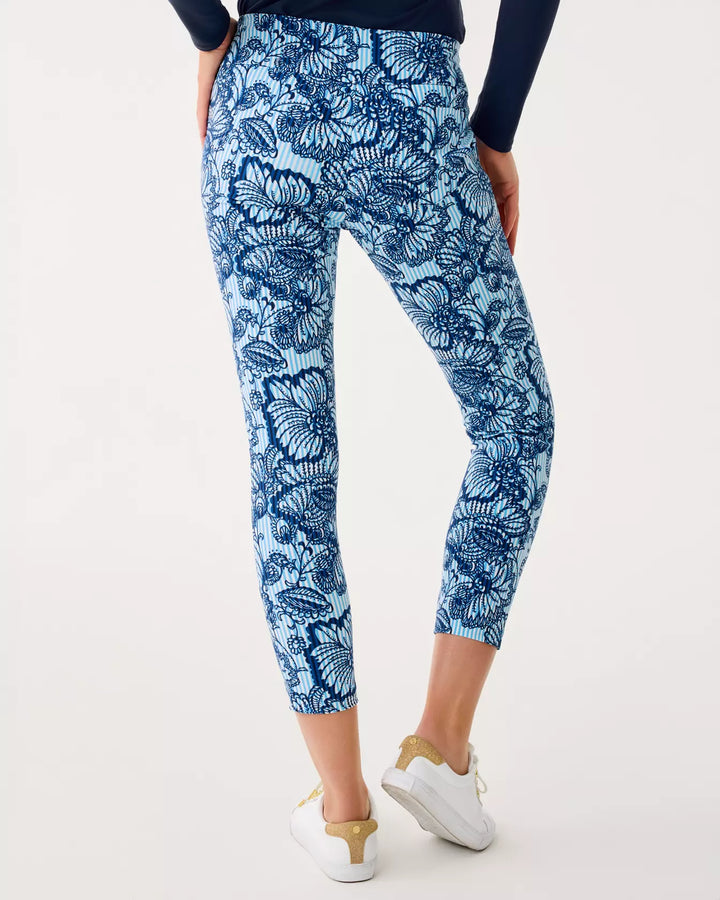 Person wearing blue floral leggings on a white background