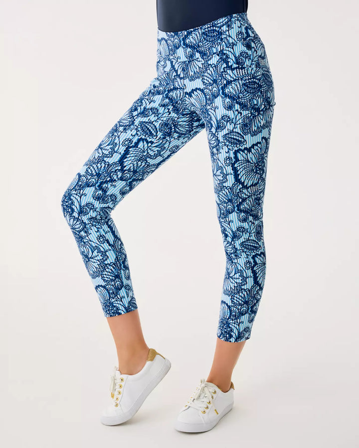 Person wearing blue floral leggings on a white background