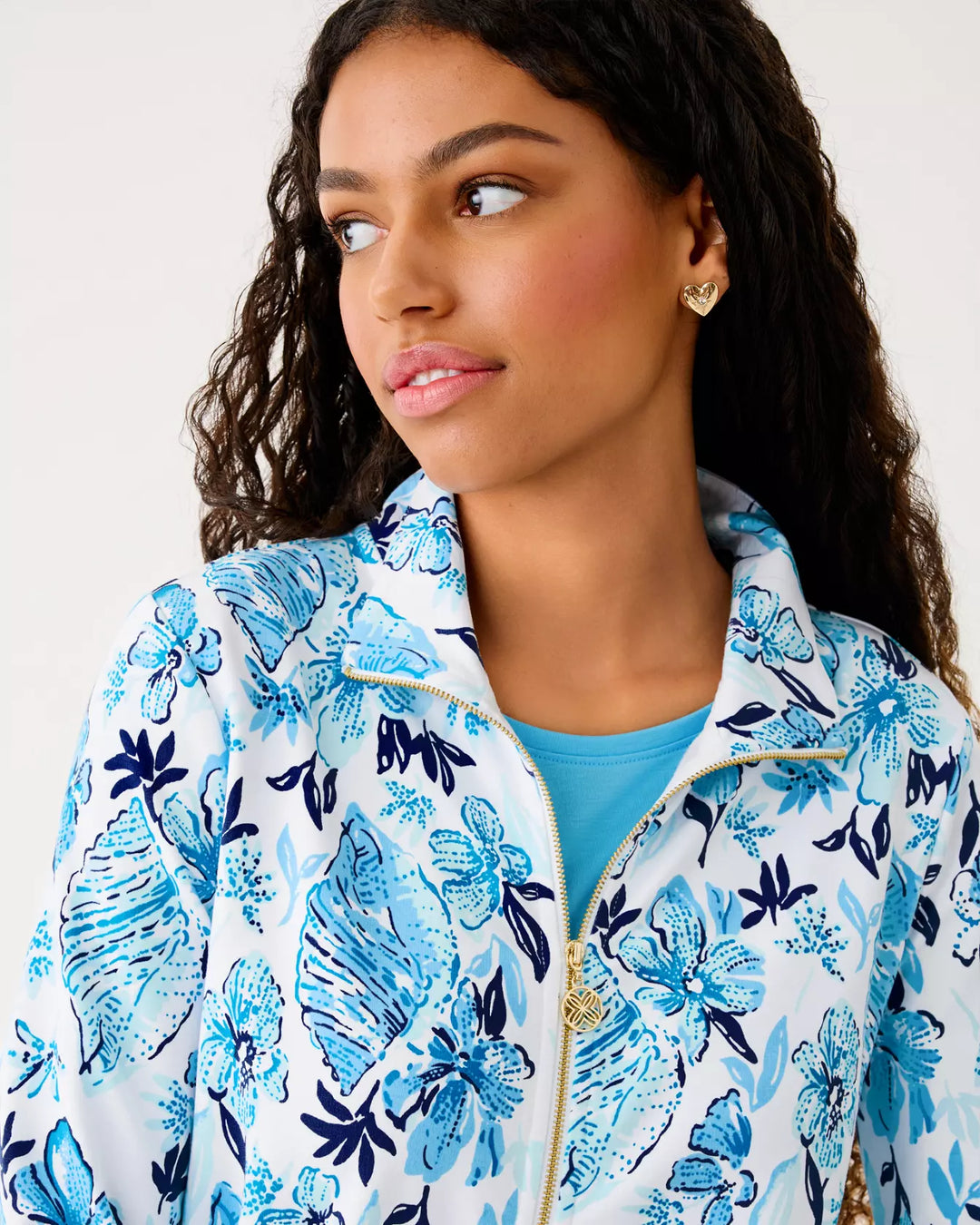 Woman wearing a blue floral jacket with a plain background