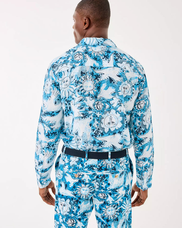 Man wearing a blue floral patterned shirt and pants on a white background