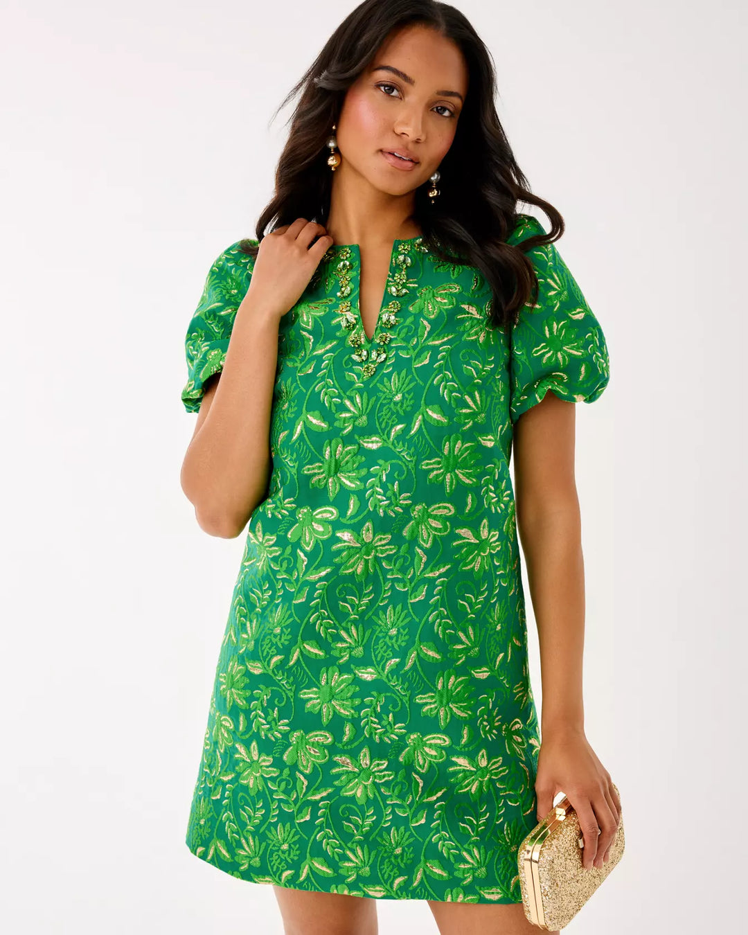 Woman wearing a green floral dress against a white background