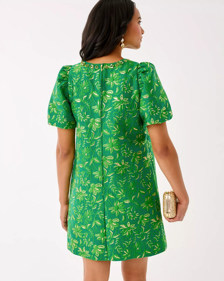 Woman wearing a green dress with a floral pattern on a white background