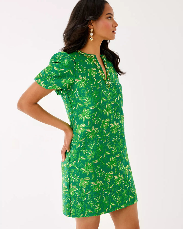 Woman wearing a green floral dress on a white background