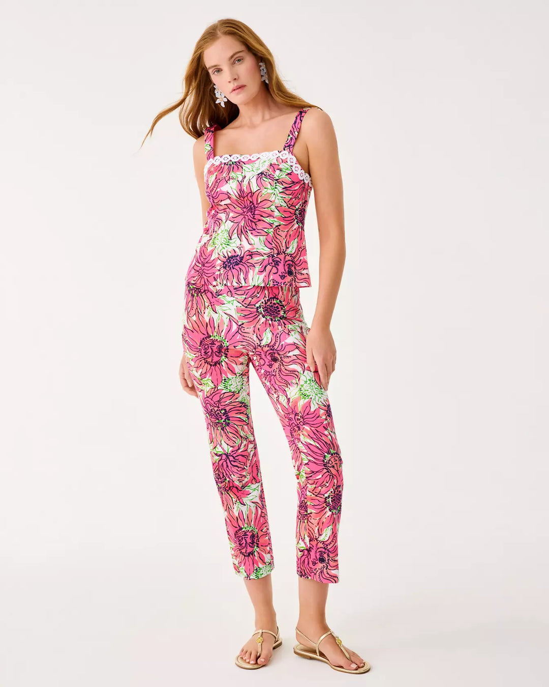 Woman wearing a pink floral top and pant on a white background