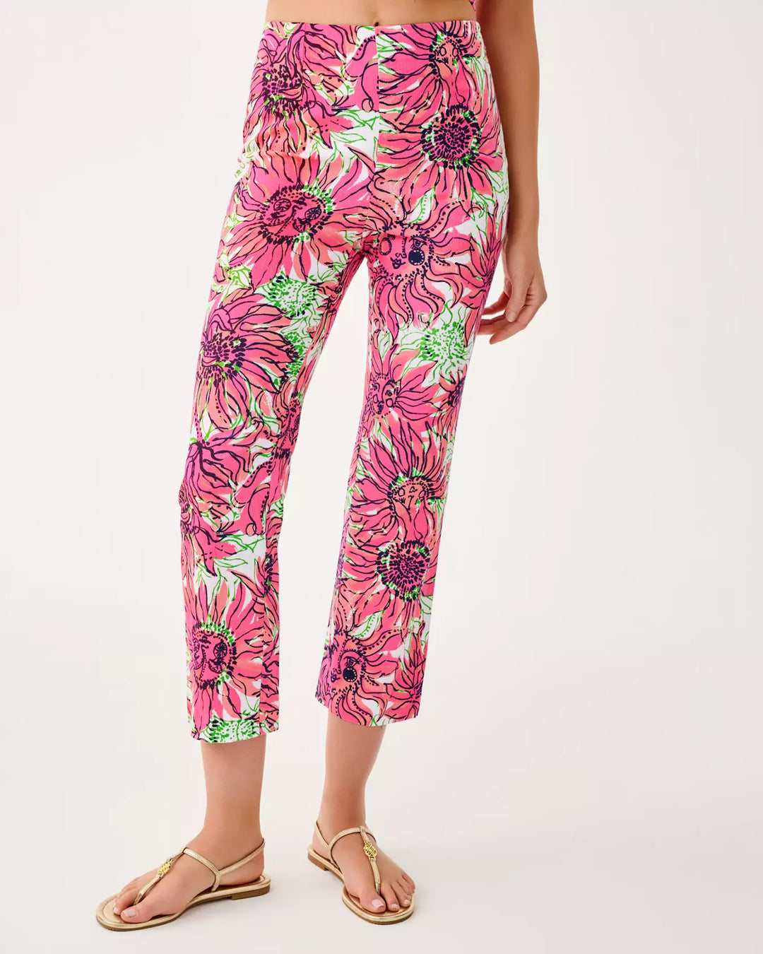 Person wearing pink floral capri pants on a white background