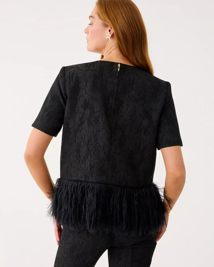 Black textured top with feathered bottom worn by a person on a white background