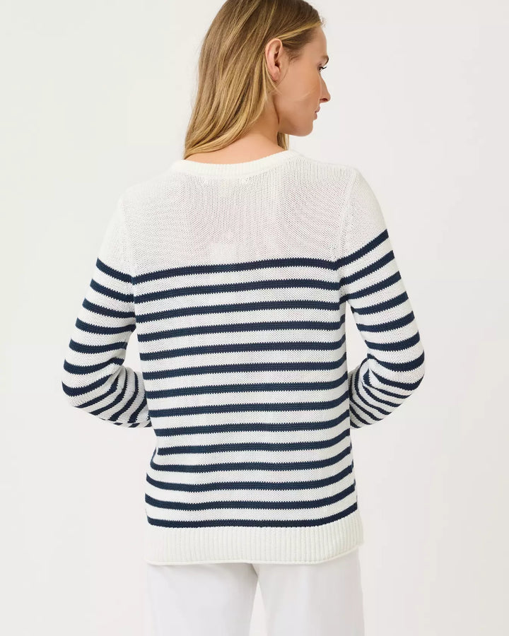 Woman wearing a white sweater with blue stripes on a plain background