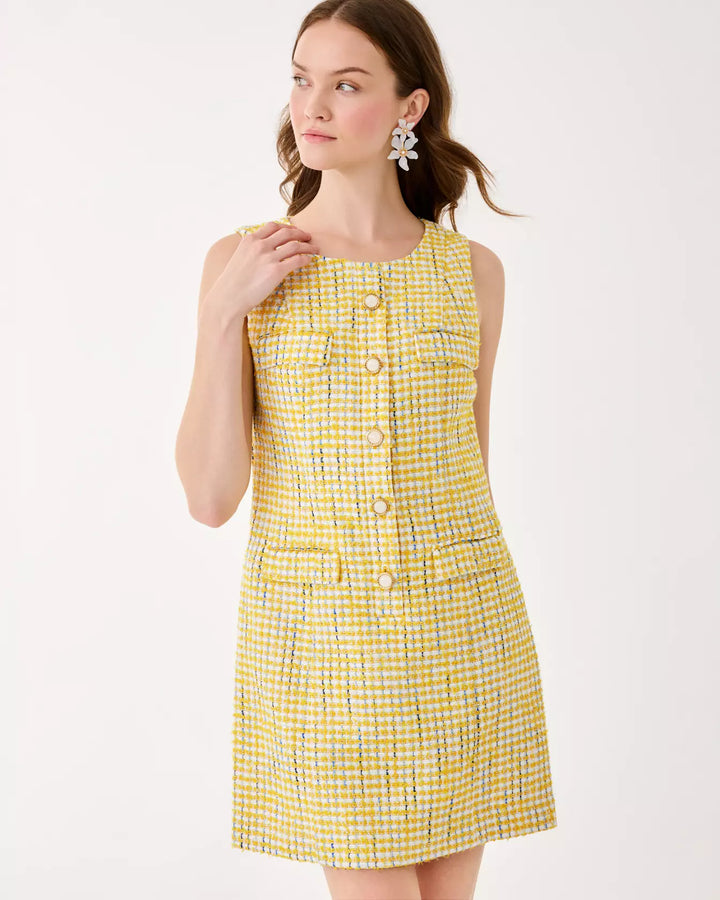 Woman wearing a yellow checkered dress on a white background