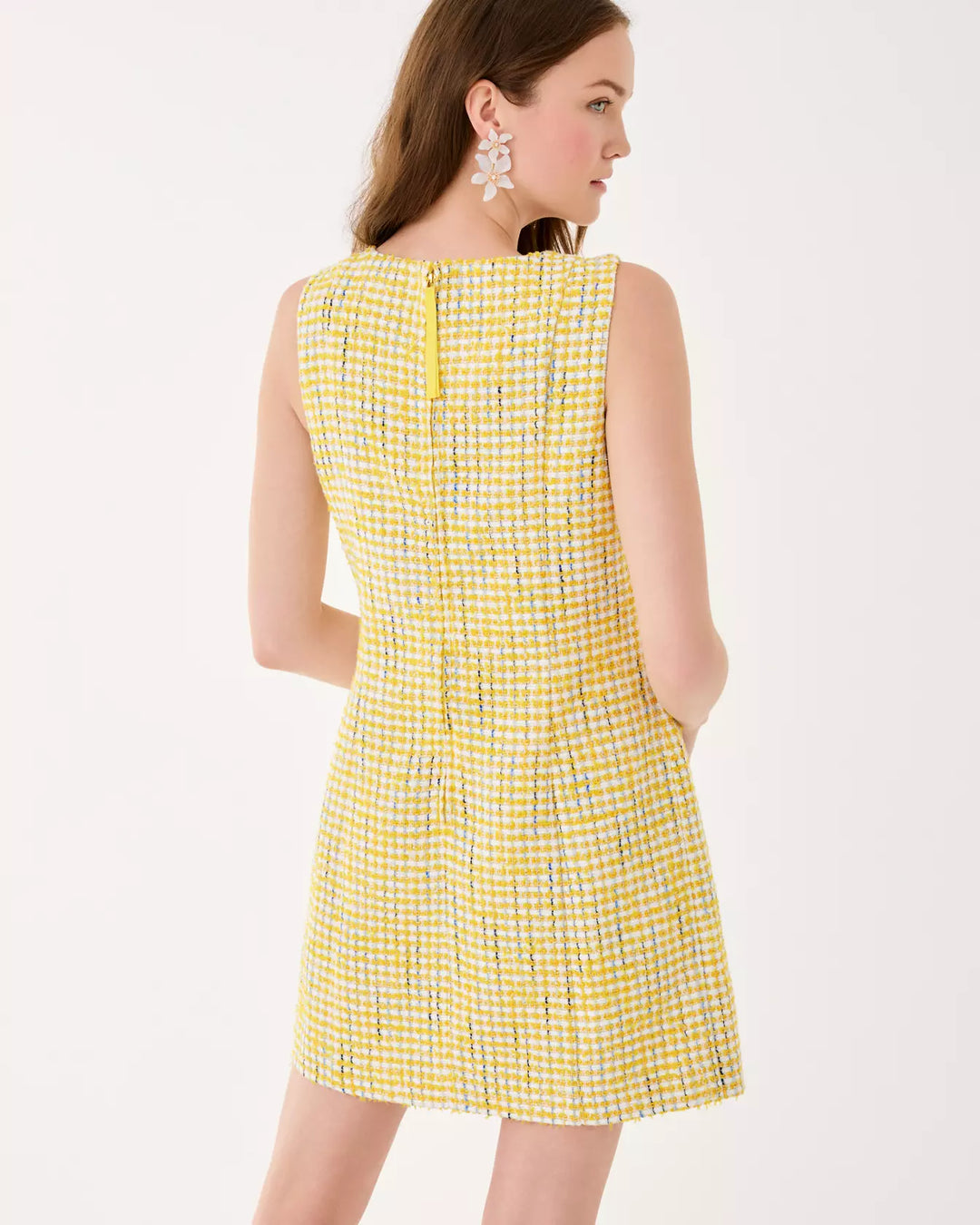 Woman wearing a yellow checkered dress on a white background