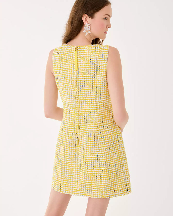 Woman wearing a yellow checkered dress on a white background
