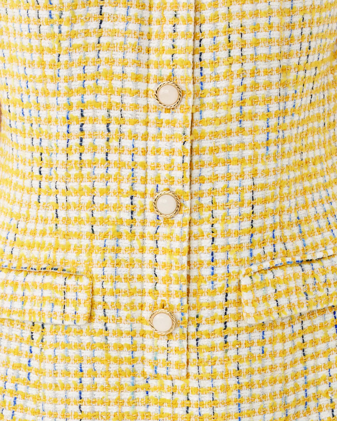 Close-up of a yellow textured fabric with buttons