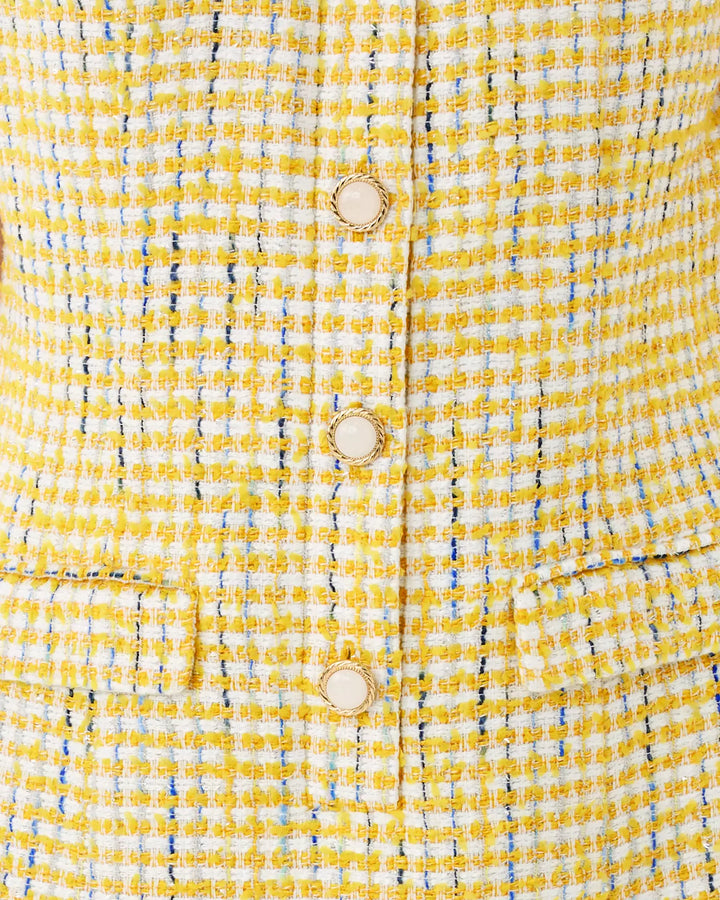 Close-up of a yellow textured fabric with buttons