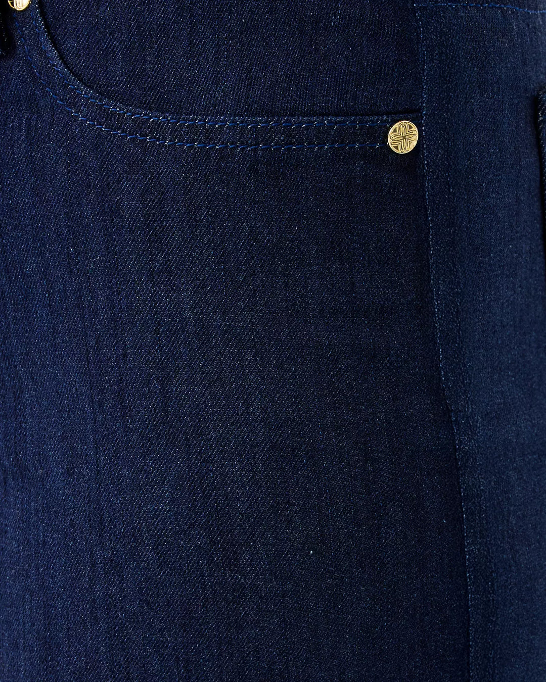 Close-up of a navy blue denim pocket with gold buttons.