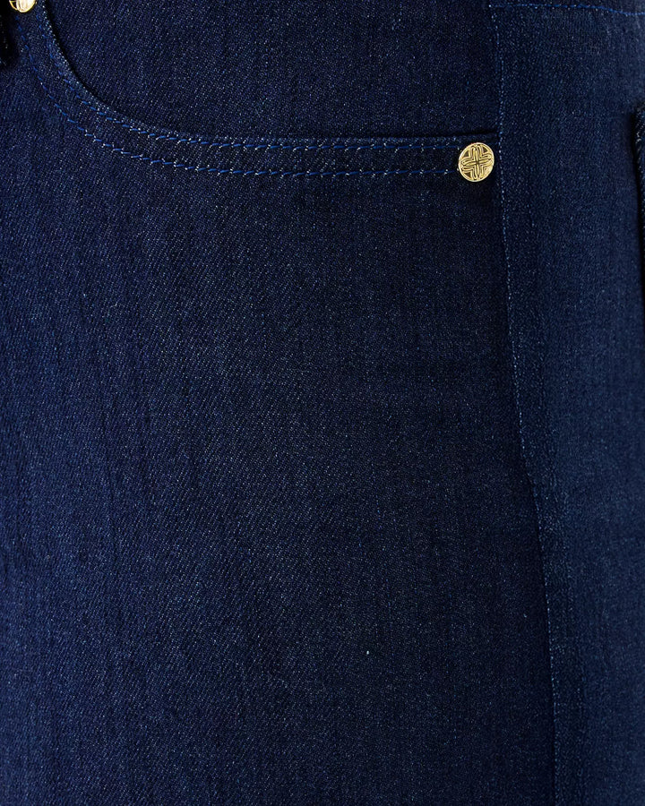 Close-up of a navy blue denim pocket with gold buttons.