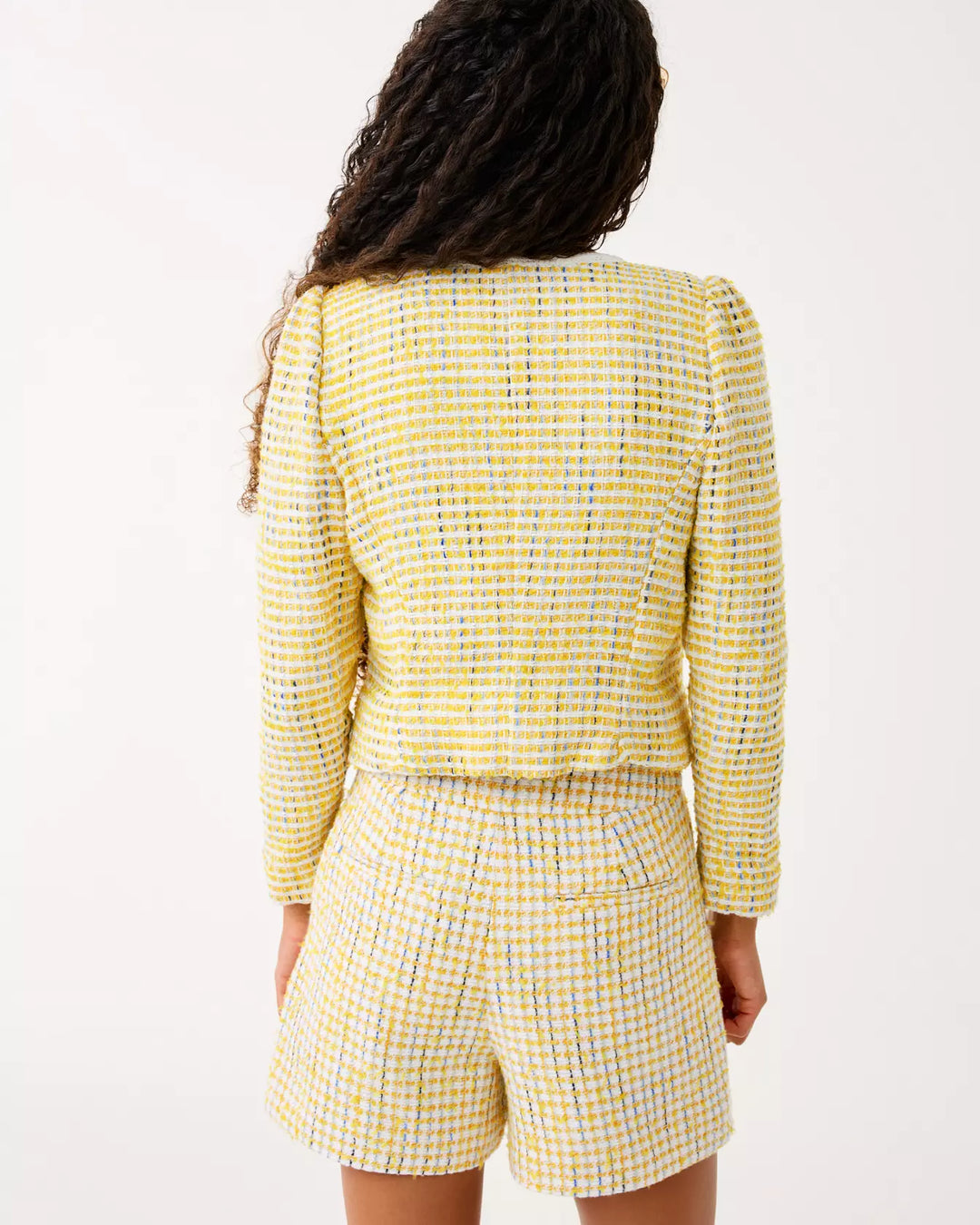 Person wearing a yellow checkered outfit on a white background