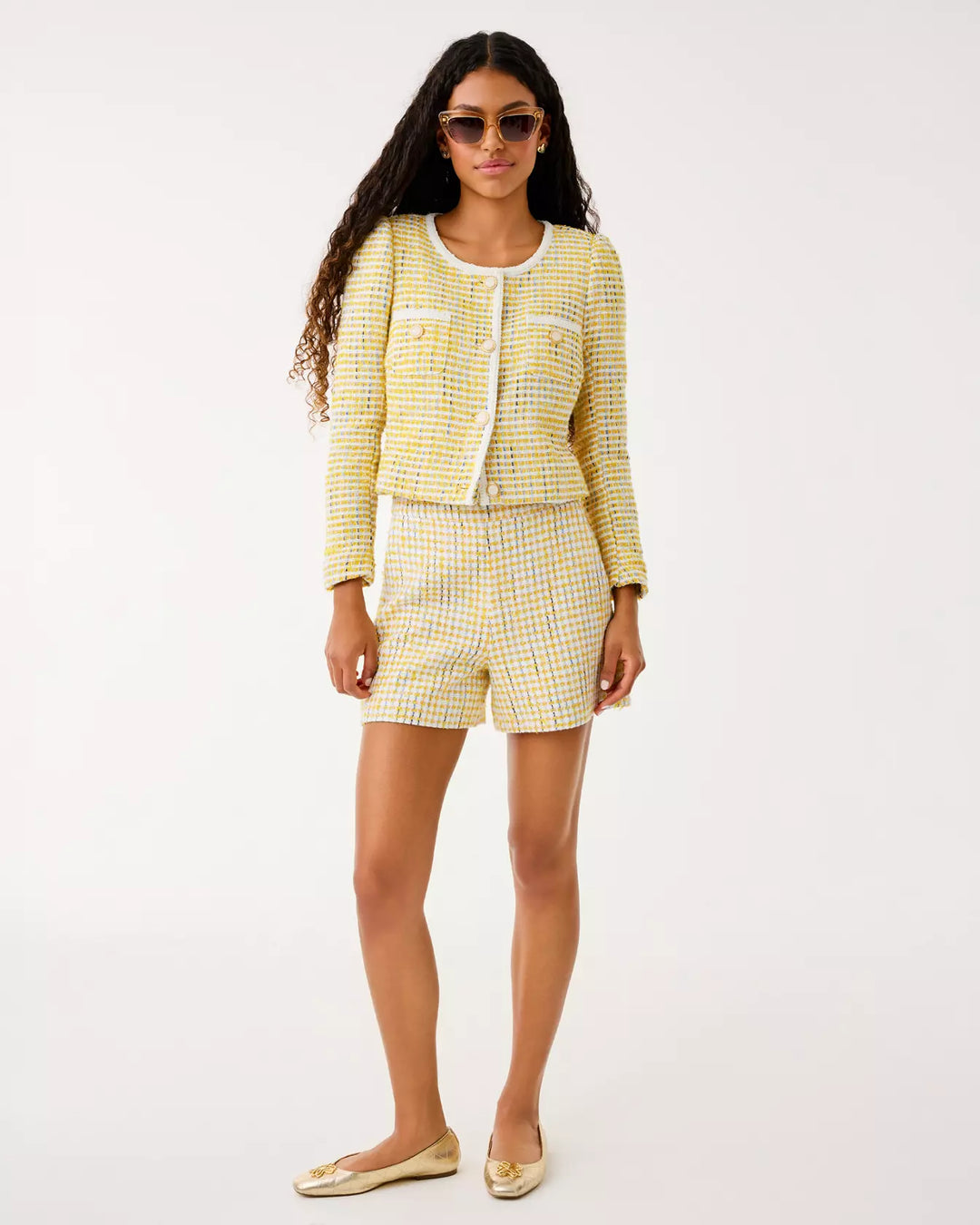 Woman wearing a yellow checkered outfit on a white background
