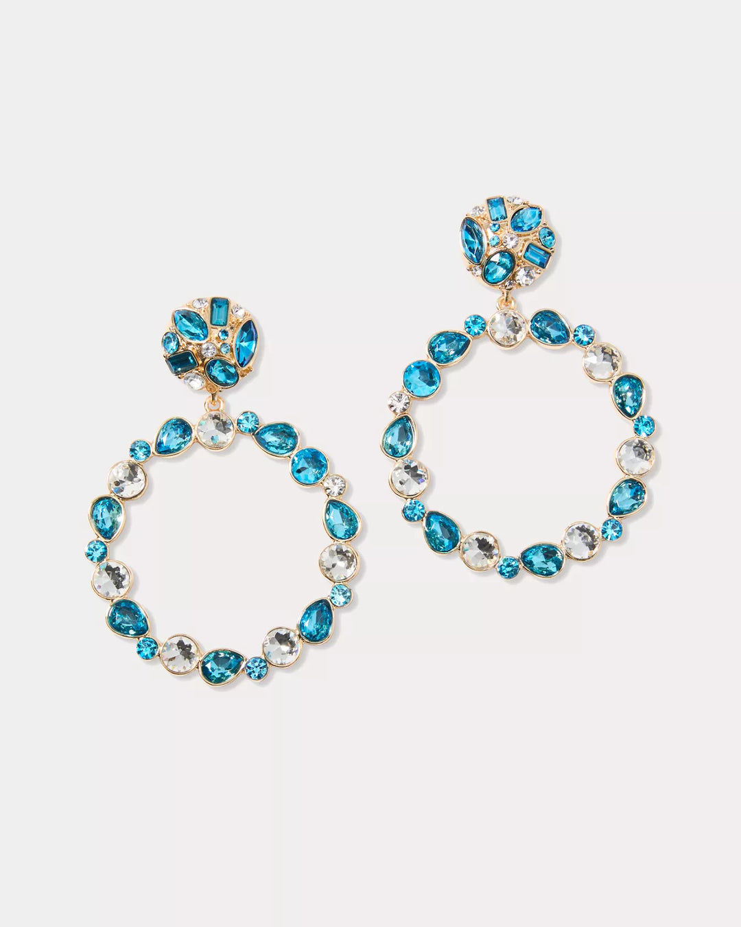 Pair of hoop earrings with blue gemstones on a light gray background