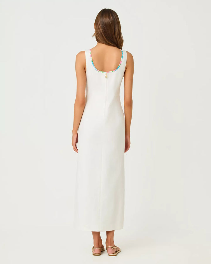 The back of a woman wearing a white sleeveless dress on a plain background