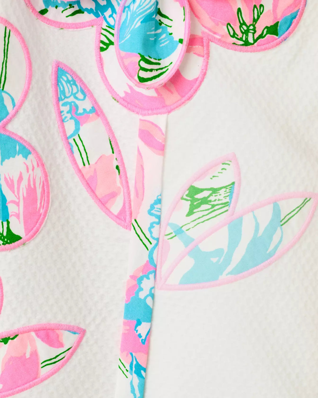 Colorful floral-shaped appliques with pink, blue, and green details on a white background