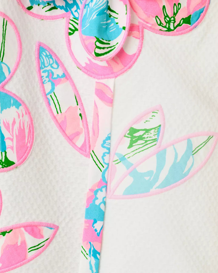 Colorful floral-shaped appliques with pink, blue, and green details on a white background