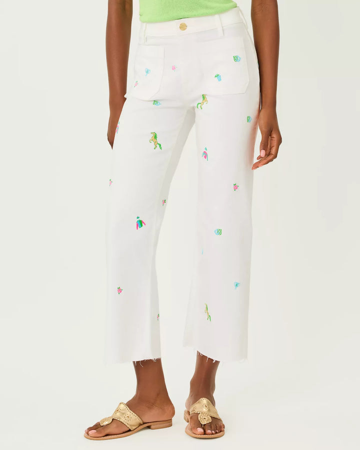White pants with colorful embroidery worn by a person on a white background