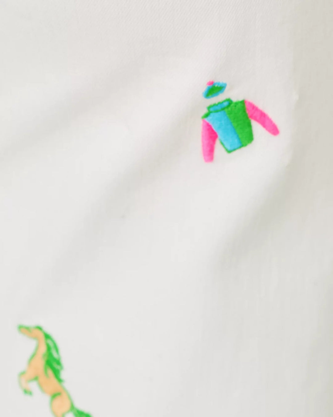 detail of derby embroidery on white pants