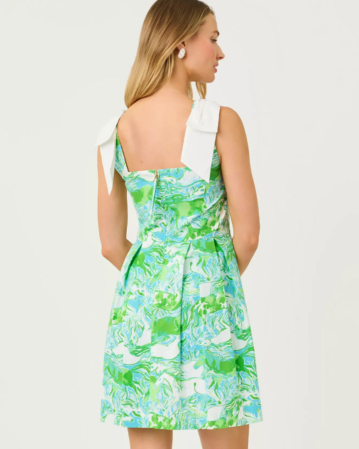 Woman wearing a green floral dress with a white bow on a white background
