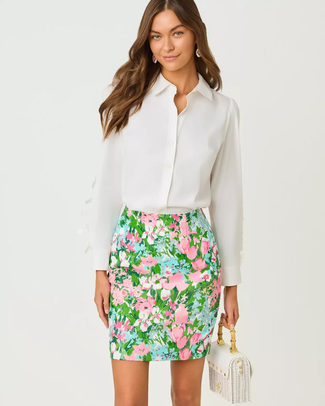Woman wearing a white blouse and floral skirt on a white background