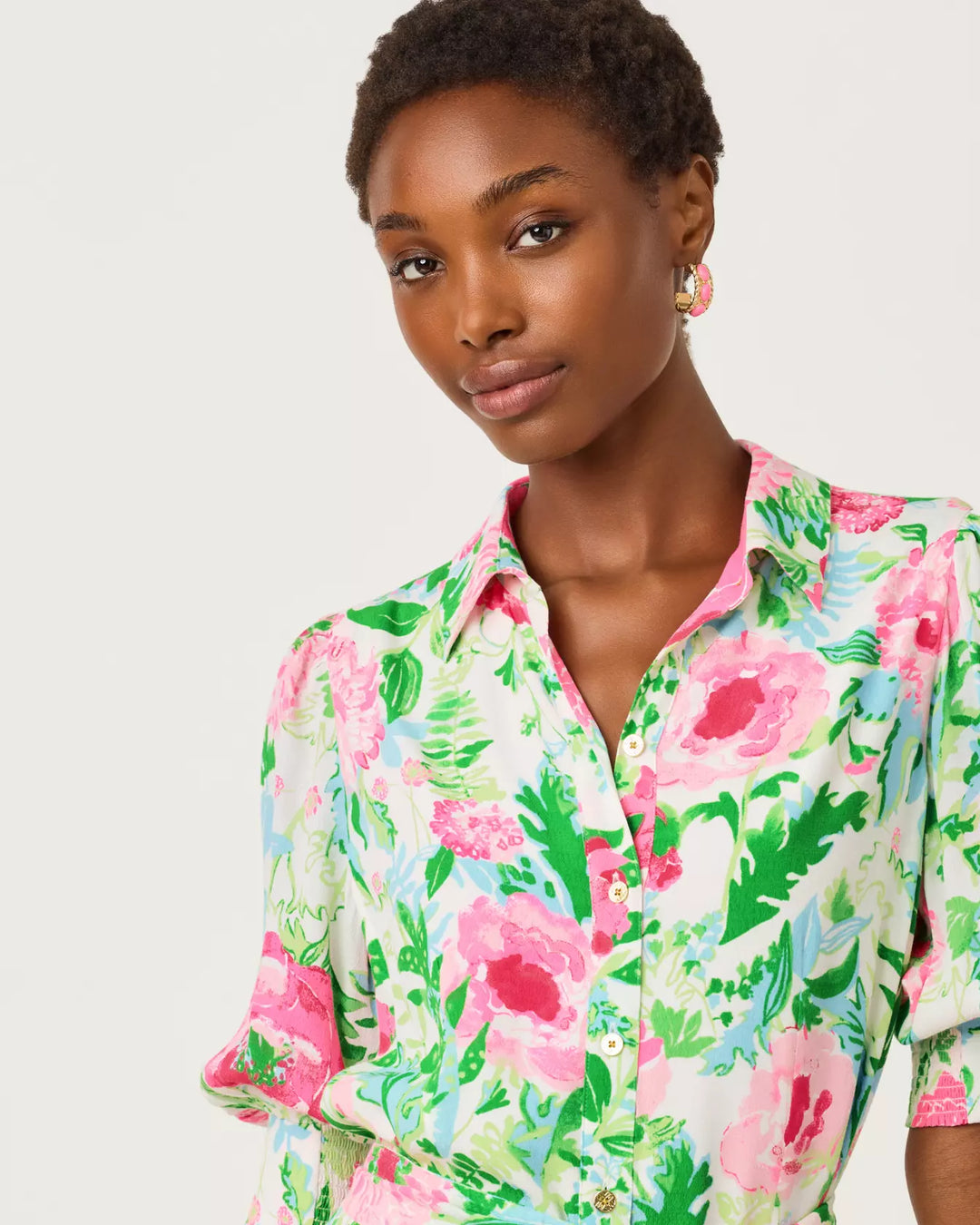Woman wearing a floral patterned shirt against a plain background